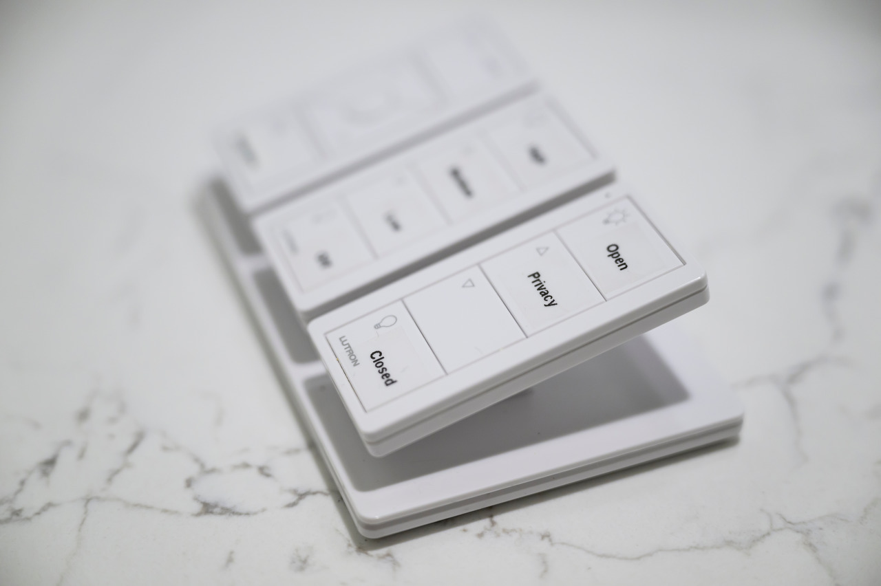 A Lutron Pico remote on a tabletop stand with buttons labeled Open, Privacy, and Closed.